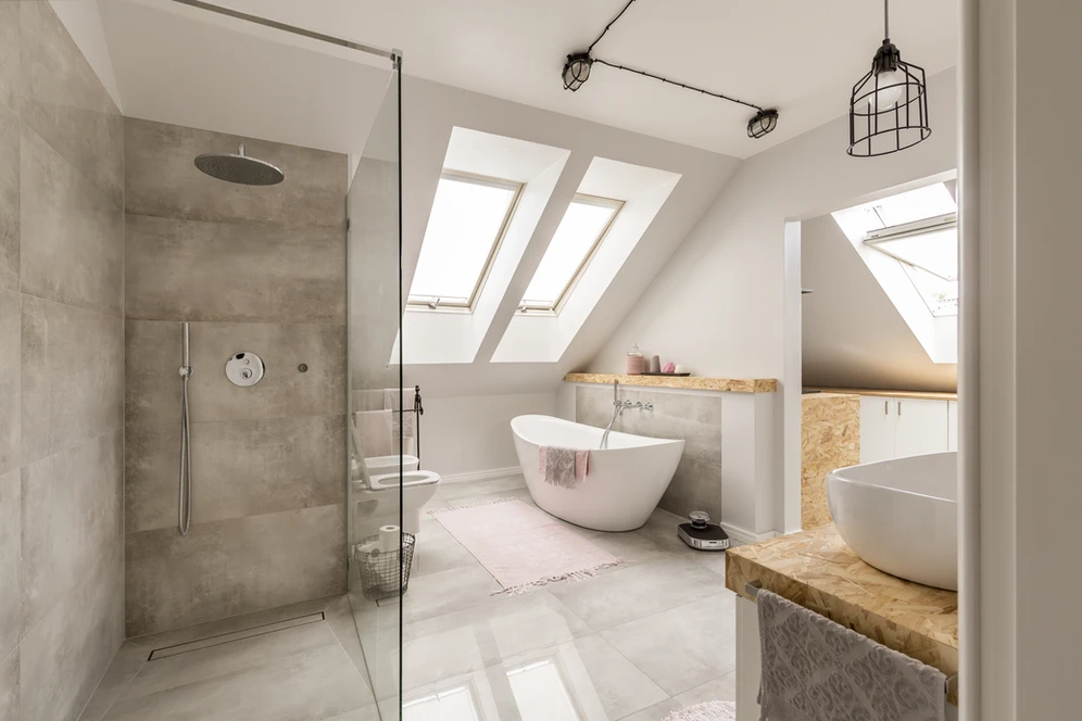 A bathroom with a white tub, a sleek sink, and a window overlooking a serene view. A bathroom with a white tub, a sleek sink, and a window overlooking a serene view.